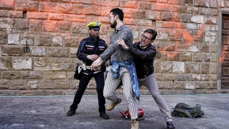 El alcalde de Florencia Dario Nardella se enfrenta a dos activistas que arrojaron pintura naranja a la fachada del Palacio Vecchio.