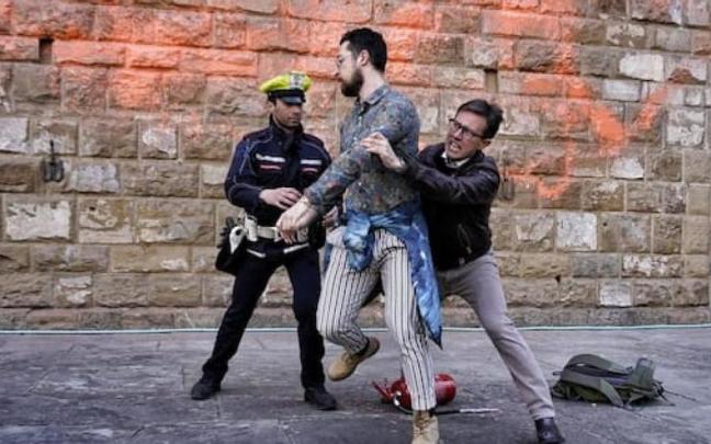 El alcalde de Florencia Dario Nardella se enfrenta a dos activistas que arrojaron pintura naranja a la fachada del Palacio Vecchio.