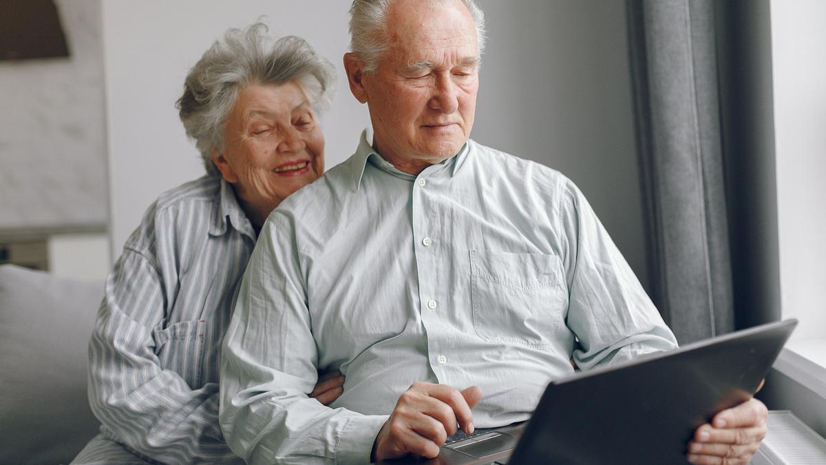 Una pareja de jubilados contempla un ordenador.