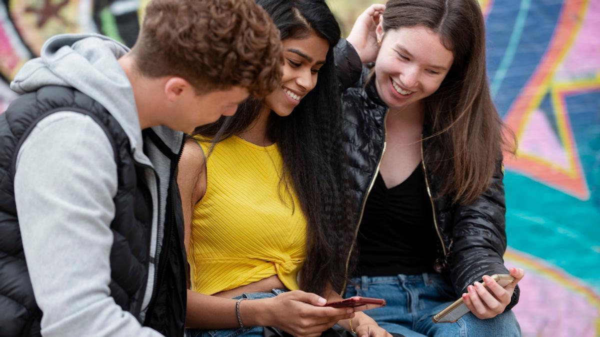 Jóvenes de la Generación Z pegados a sus teléfonos móviles.