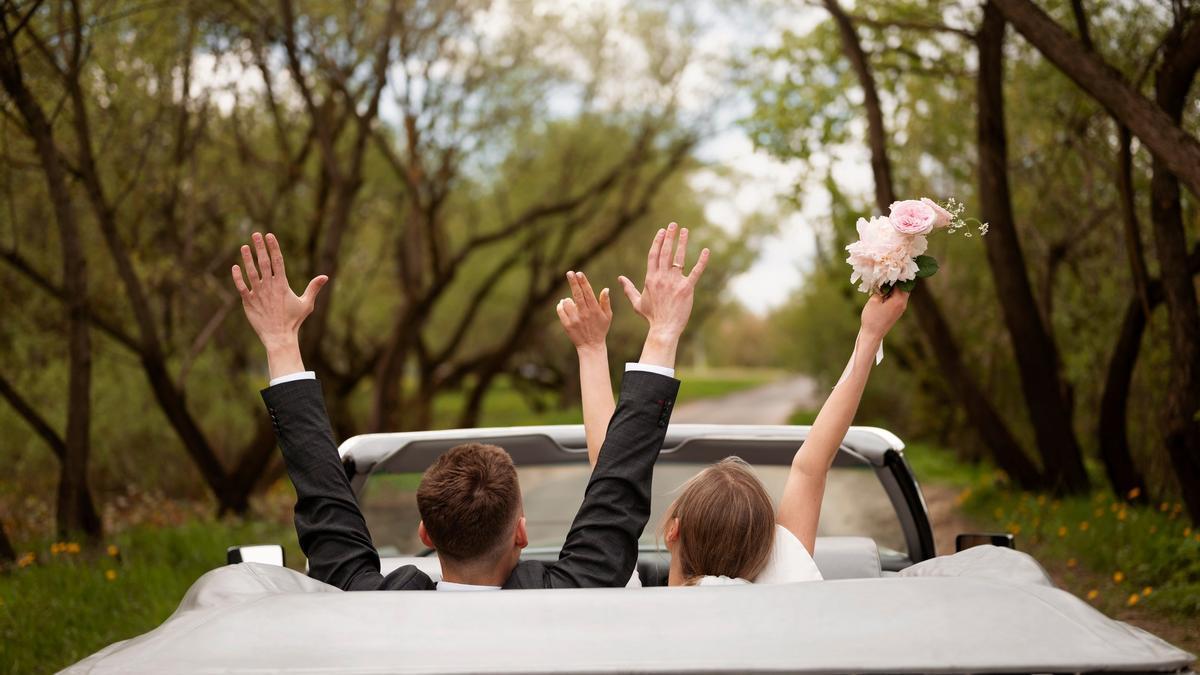 Una pareja abandona el lugar del banquete en su coche.
