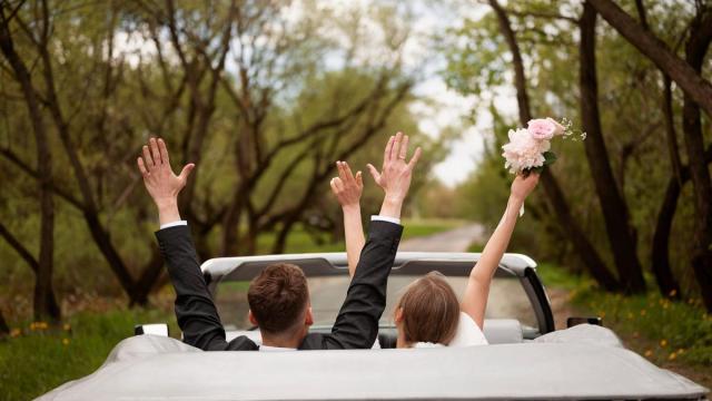 Una pareja abandona el lugar del banquete en su coche.