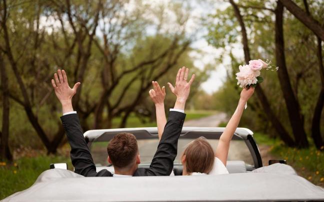 Una pareja abandona el lugar del banquete en su coche.