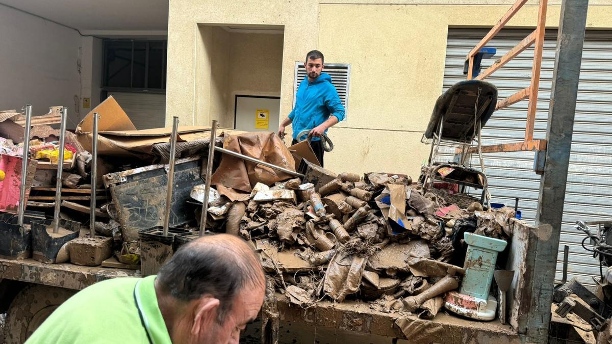 Vecinos de Guadasuar retiran escombros de la vía pública.