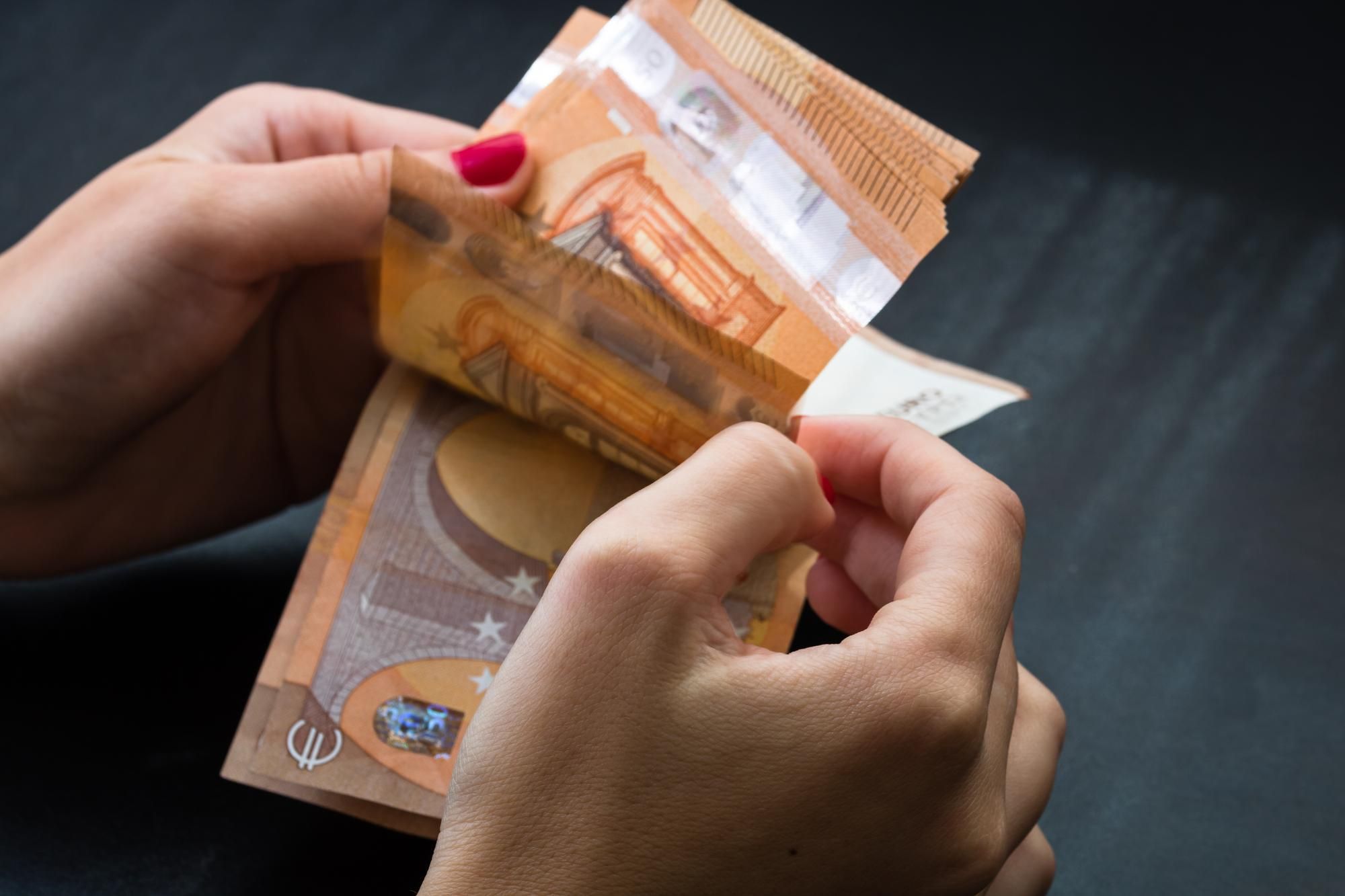 Una mujer cuenta billetes de 50 euros.