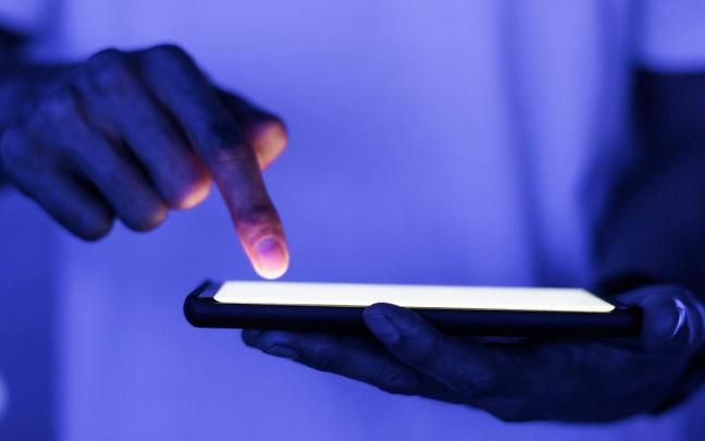 Un usuario introduce un código en su smartphone.