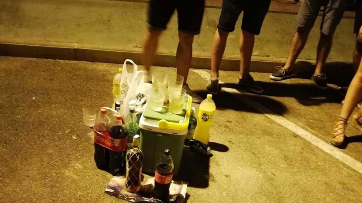 Unos jóvenes practican botellón.