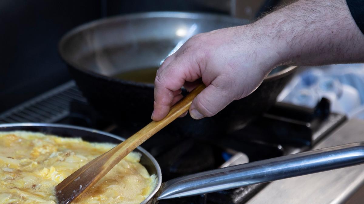 Un cocinero prepara una tortilla de patatas.