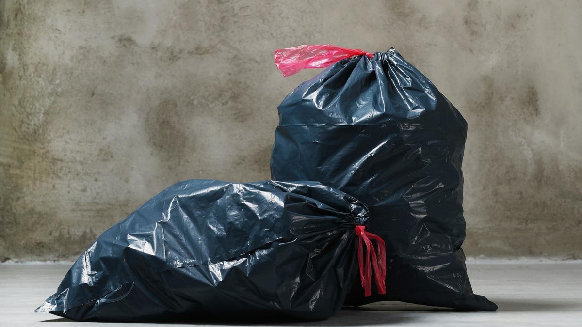 Dos bolsas de basura listas para ser depositadas en el contenedor.