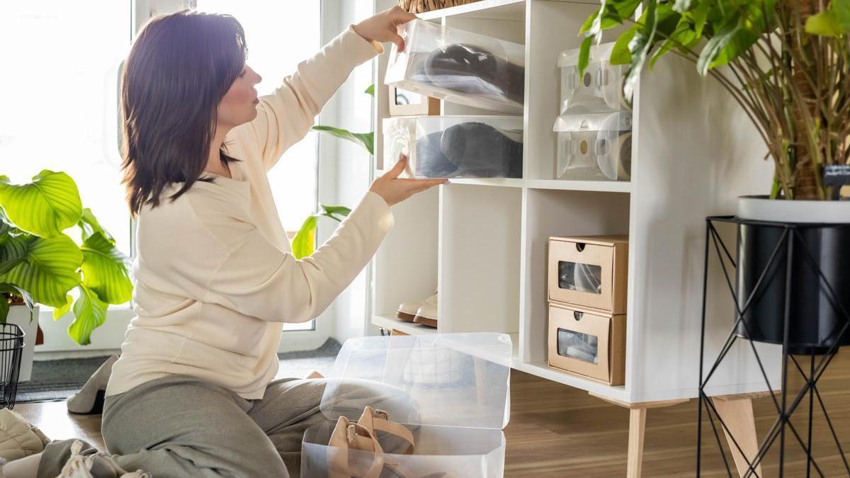 Mujer ordena sus zapatos y los clasifica en diferentes cajas.