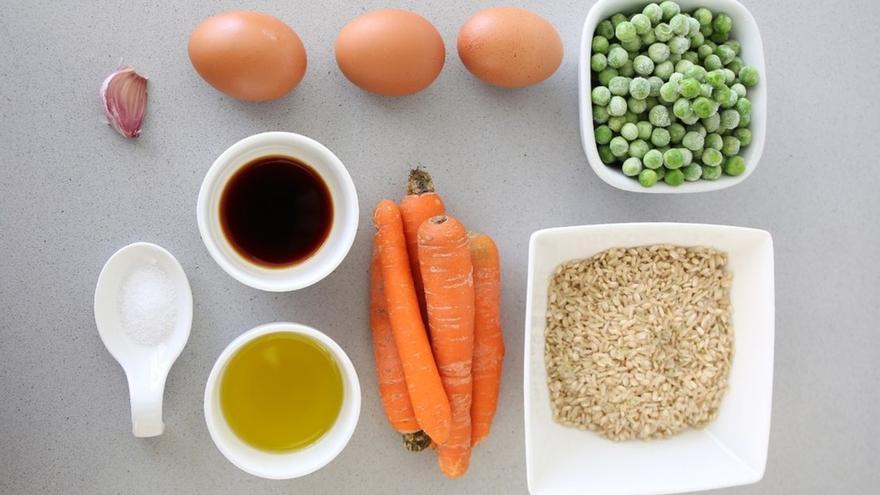 El arroz cocido del día anterior puede transformarse en una cena rápida con huevo, zanahoria, guisantes y un toque de salsa de soja.