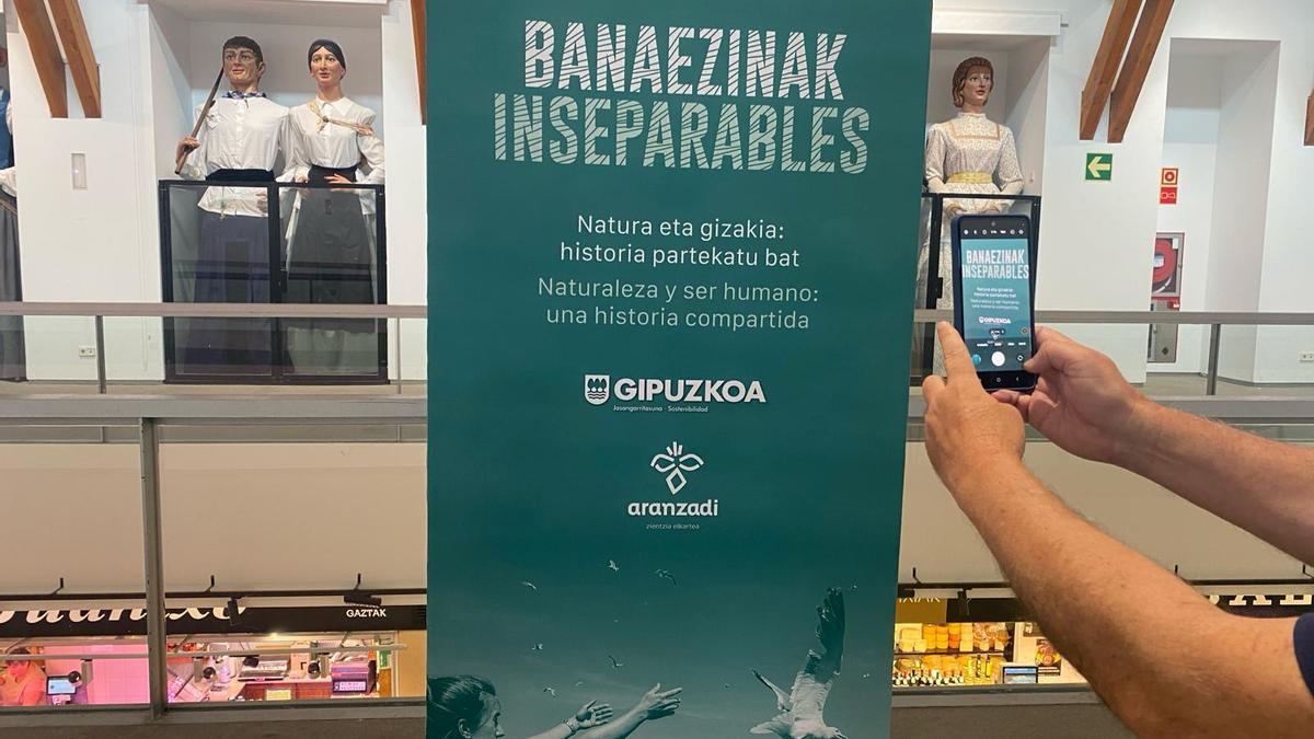 Persona sacando foto al cartel de la exposición 'Inseparables'.