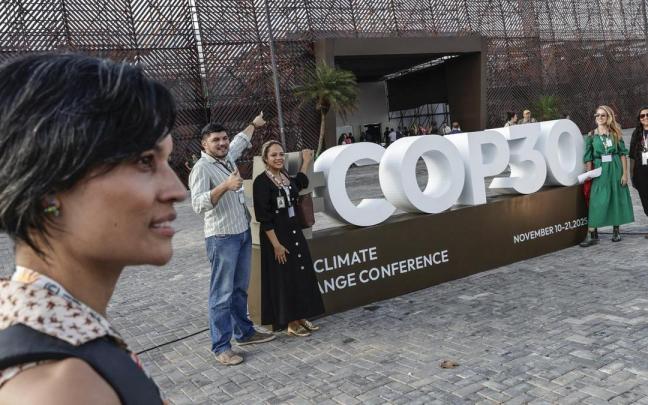Personas se toman una fotografía junto a un cartel de la COP30, en Belém (Brasil).