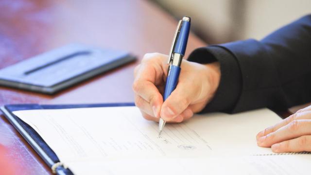 Una persona firmando una hipoteca.