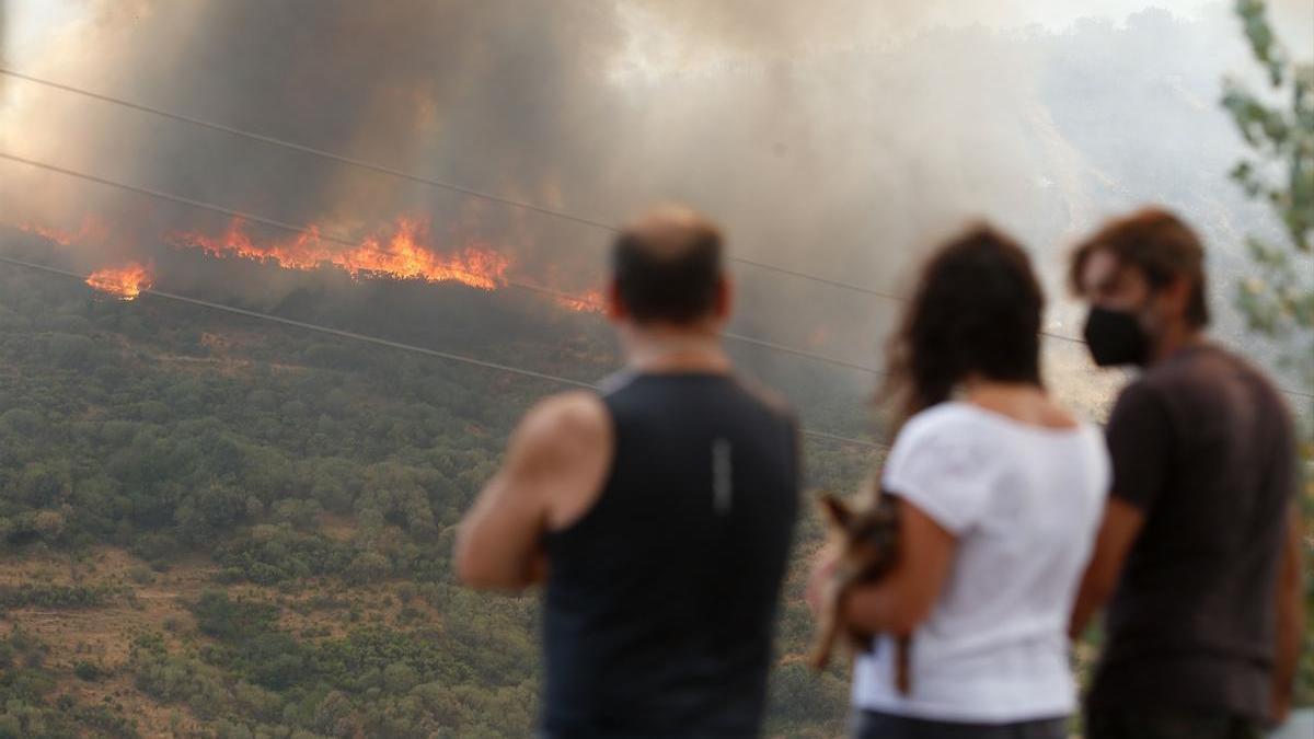 Varias personas observan el incendio forestal de La Baña (León).