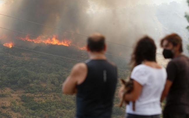 Varias personas observan el incendio forestal de La Baña (León).