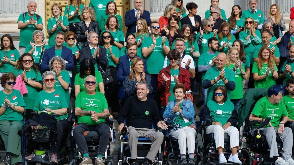 Juan Carlos Unzué, con jersey negro, celebra junto a pacientes de ELA y sus familiares la aprobación de la ley.