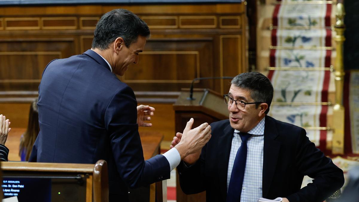 Pedro Sánchez felicita a Patxi López tras su intervención en la segunda jornada del debate de la moción de censura.