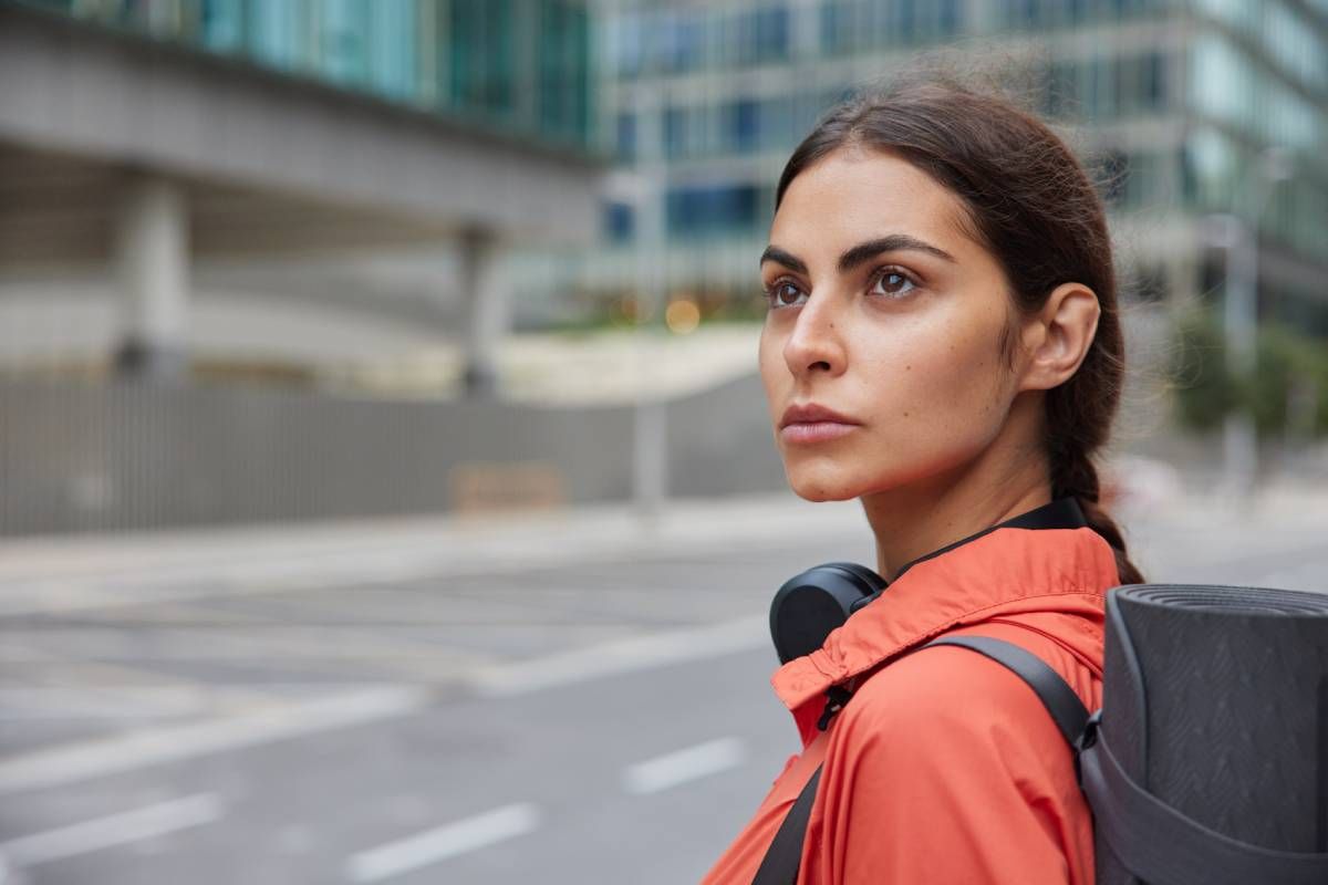 Rostro de una chica que pasea por la ciudad de camino al gimnasio.