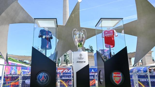 Imagen de las camisetas del Paris Saint-Germain y del Arsenal, junto el trofeo de la Champions League.