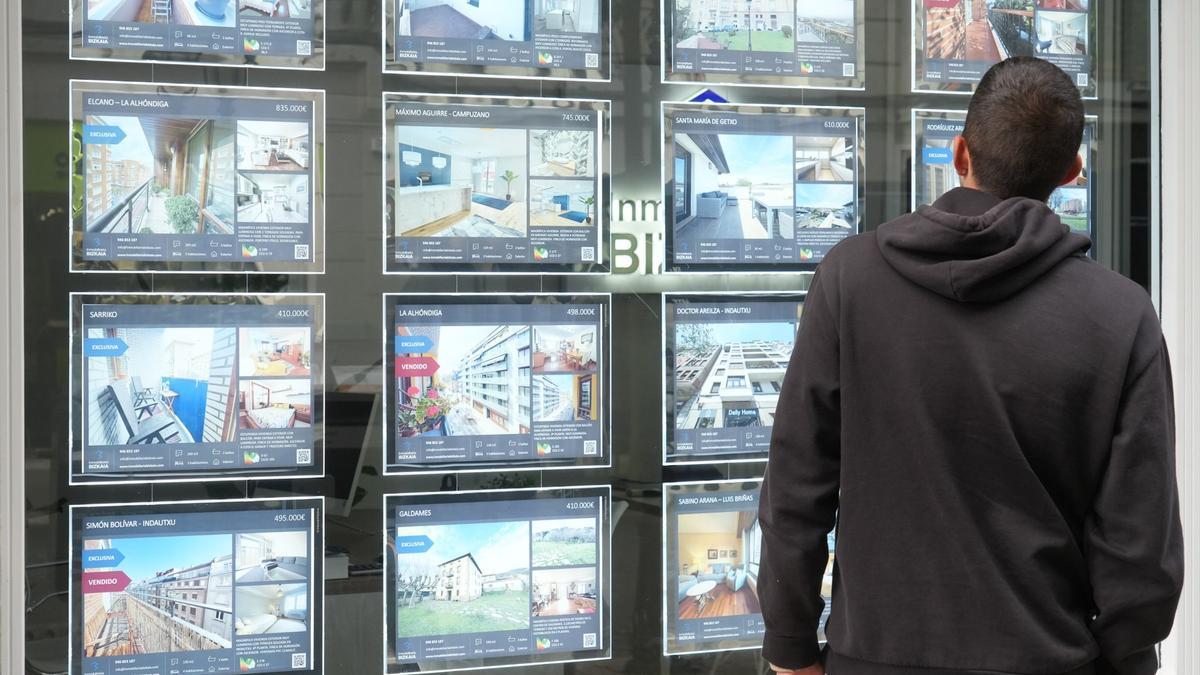 Un hombre contempla las ofertas expuestas en una inmobiliaria.