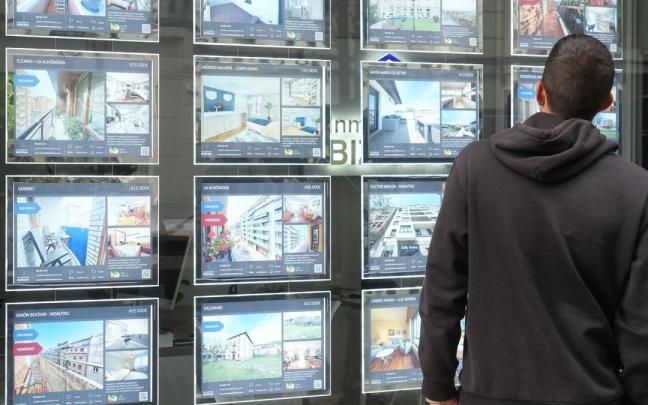 Un hombre contempla las ofertas expuestas en una inmobiliaria.