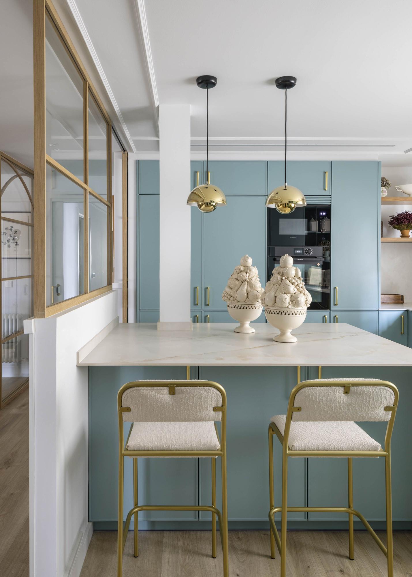 Detalle de la cocina, en un atrevido tono verde azulado combinado con detalles dorados.