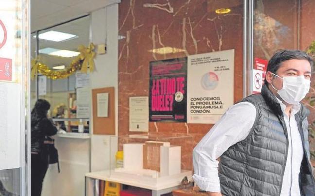 Un hombre sale de un centro de salud con mascarilla
