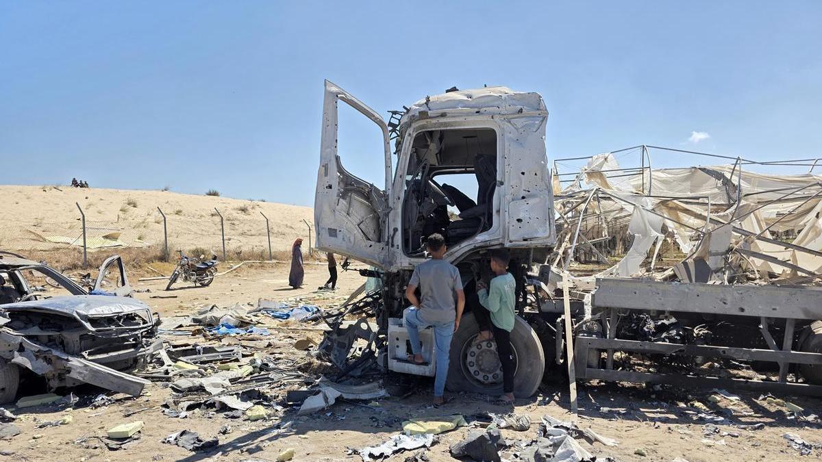 Dos palestinos observan los restos de un camión destruido en Jan Yunis.