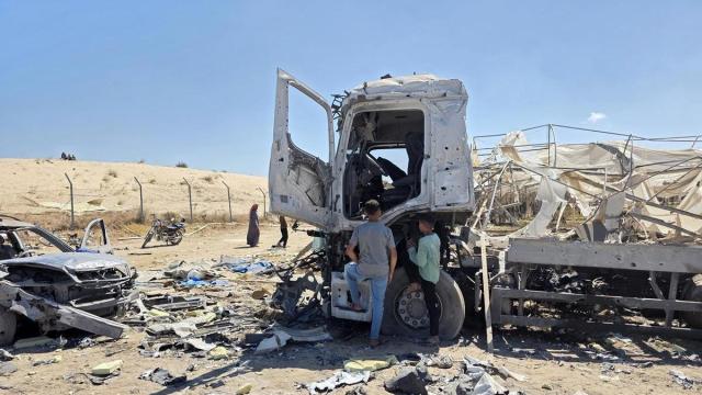 Dos palestinos observan los restos de un camión destruido en Jan Yunis.
