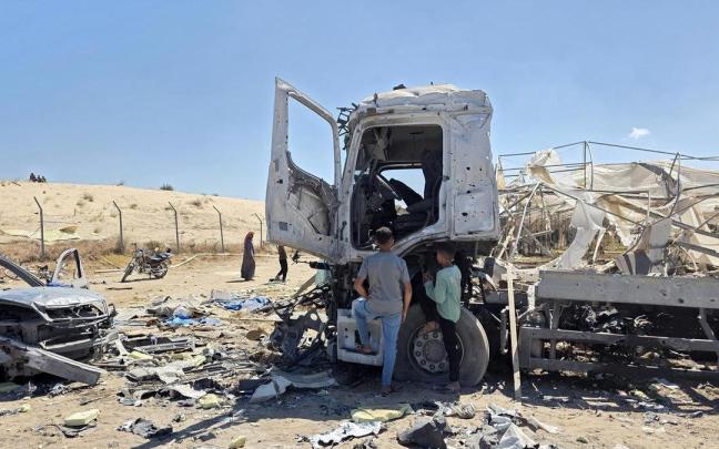 Dos palestinos observan los restos de un camión destruido en Jan Yunis.
