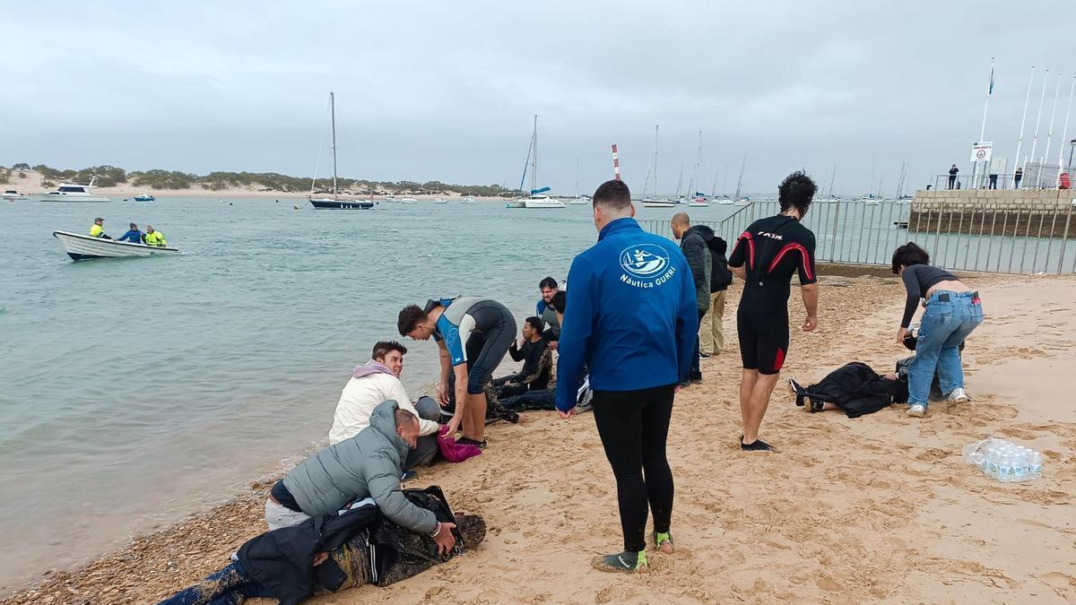 Varias personas atienden a algunos de los 35 migrantes que fueron obligados a arrojarse al mar por los tripulantes de una narcolancha.