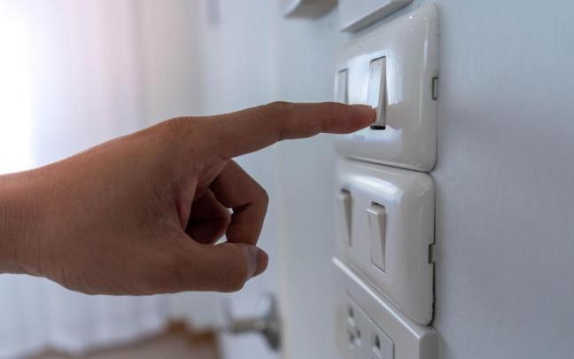 Una persona enciende un interruptor de luz. / Freepik Una persona enciende un interruptor de luz.
