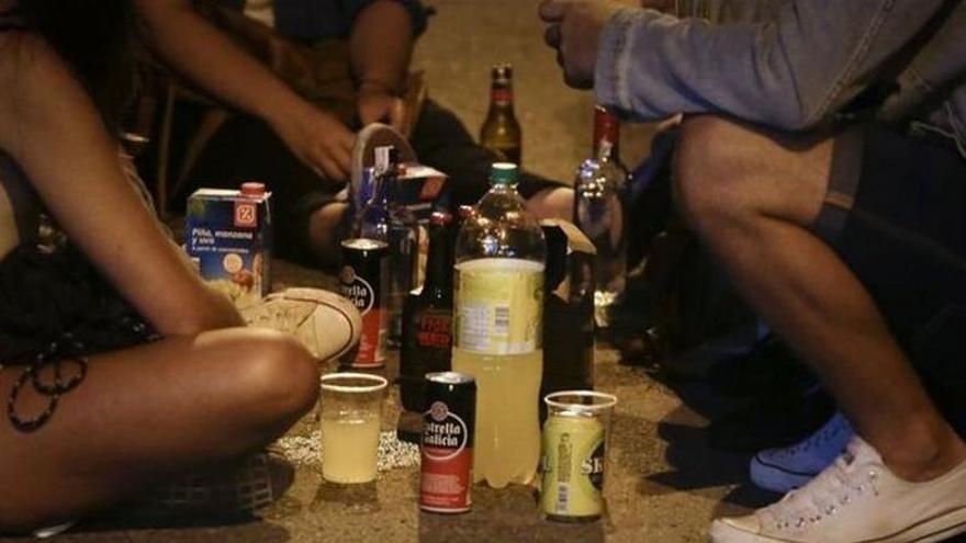 Un grupo de jóvenes bebe alcohol en la calle.