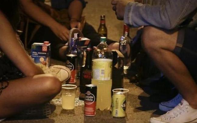 Un grupo de jóvenes bebe alcohol en la calle.