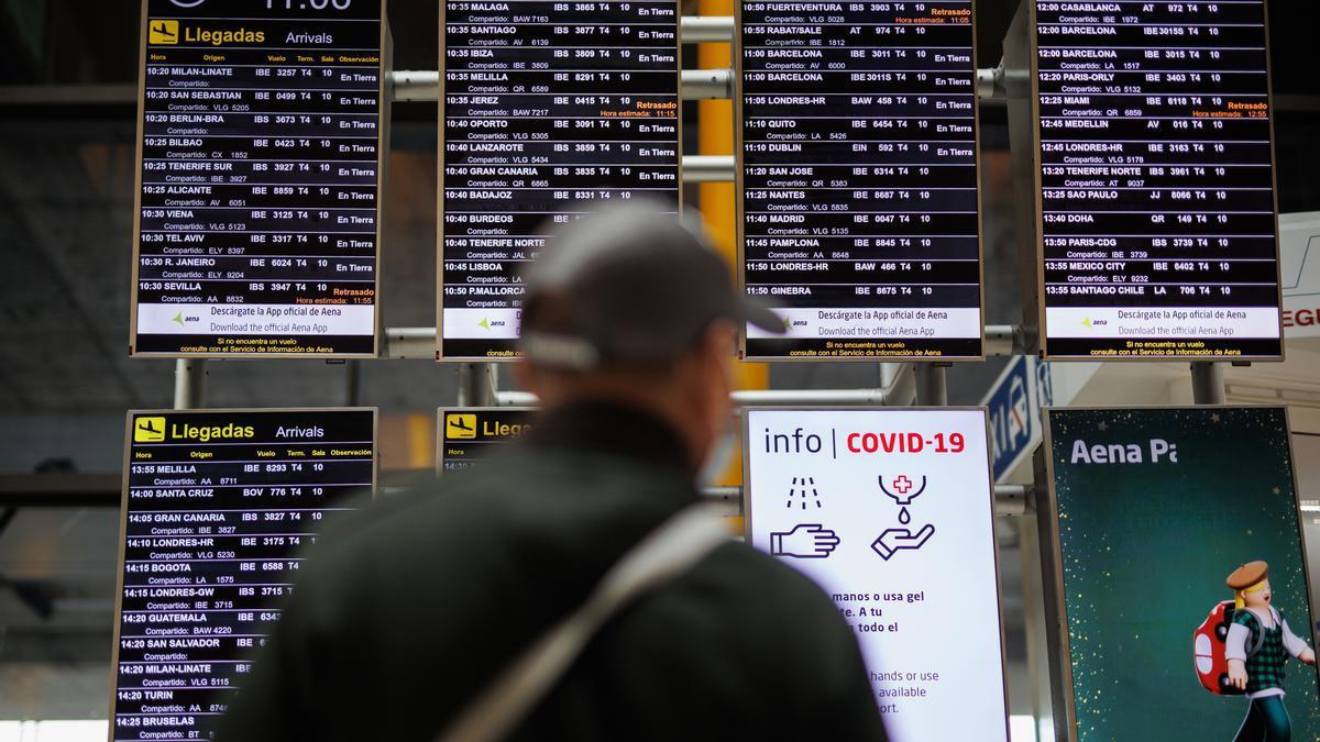 Un hombre observa los paneles informativos de vuelos en el aeropuerto de Madrid