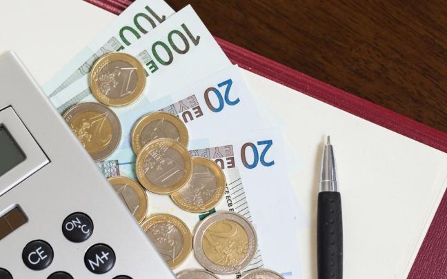 Monedas y billetes, junto a una calculadora. Monedas y billetes, junto a una calculadora.