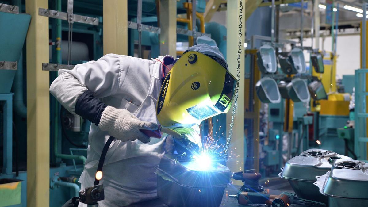 Un soldador trabajando en una planta industrial.