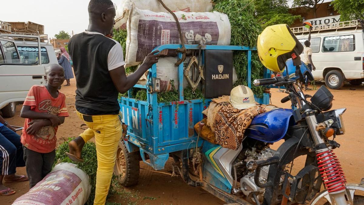 Un hombre carga su motocicleta en un mercado de Niamey, Níger