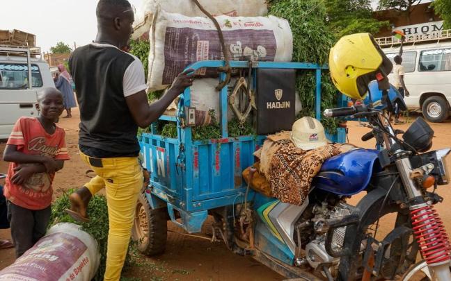 Un hombre carga su motocicleta en un mercado de Niamey, Níger