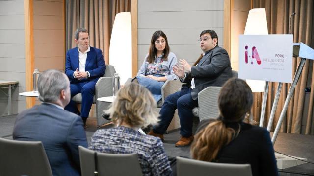 El moderador del foro, Txema Gutiérrez, y la experta de maldita.es, Patricia Ruiz Guevara, escuchan la intervención de Iñaki González.