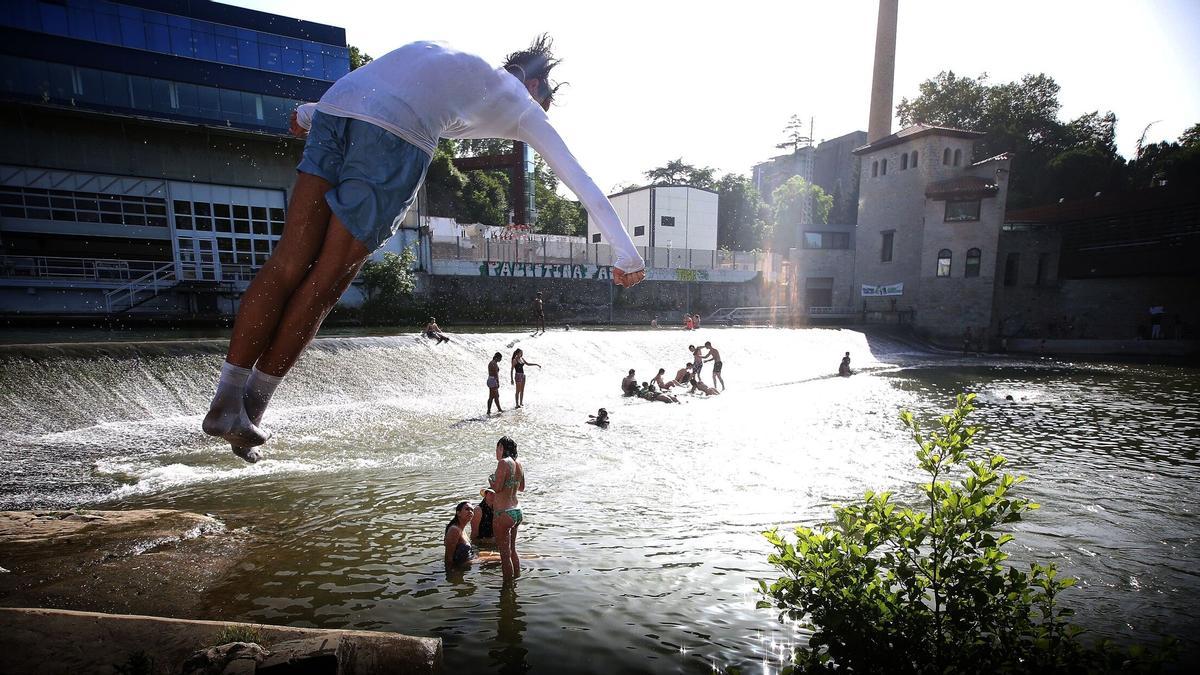 Varias personas se bañan en el río Arga (Nafarroa) el último día de la primavera.