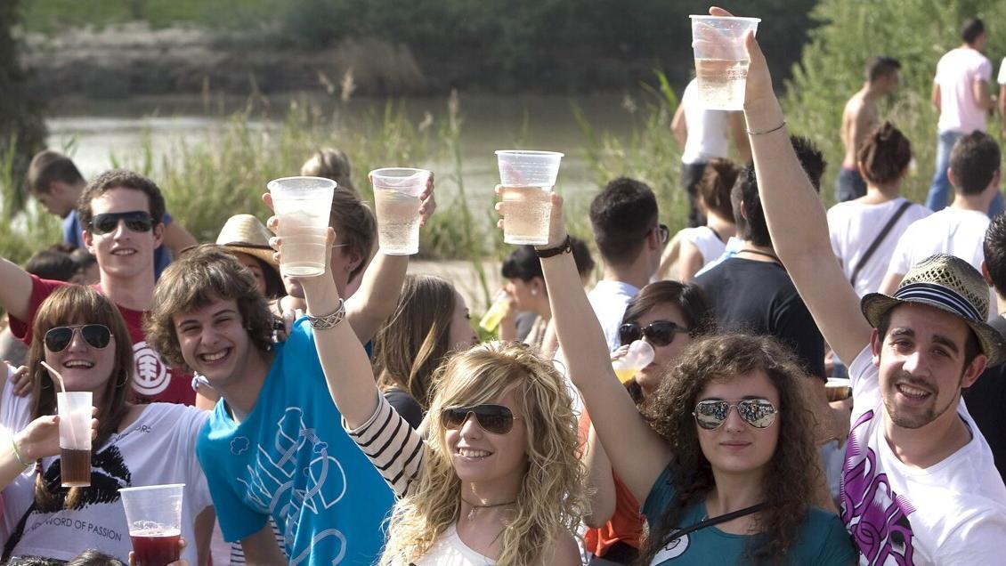 Unos jóvenes posan con sus vasos durante una fiesta al aire libre.