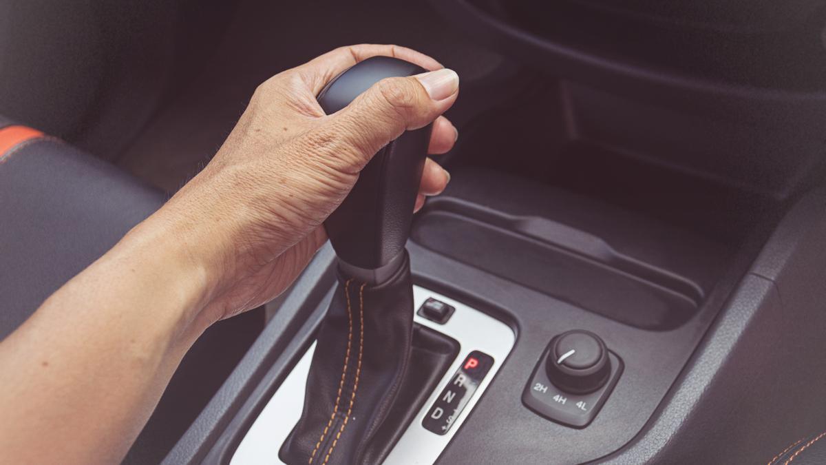 Un hombre maneja la transmisión automática de su coche.