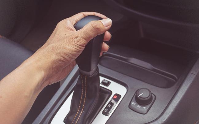Un hombre maneja la transmisión automática de su coche.