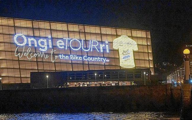 En las imágenes superiores, activación en Bilbao de la cuenta atrás para el inicio del Tour y las autoridades en bici ante el Ayuntamiento de la capital vizcaína; en las imágenes inferiores, el Kursaal y el Consistorio donostiarra