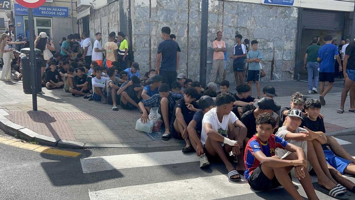 Un grupo de menores espera para ser filiado en una comisaría de Ceuta