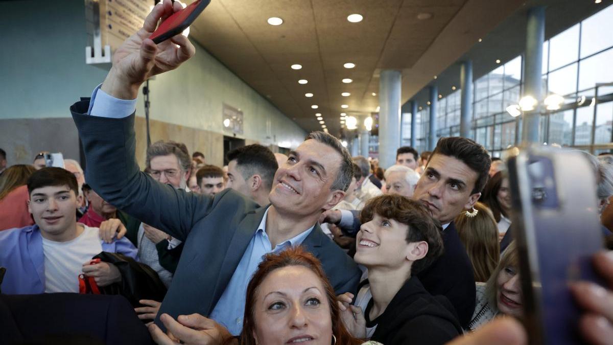 Pedro Sánchez se fotografía con dos simpatizantes mientras participa en su primer acto de la precampaña gallega.