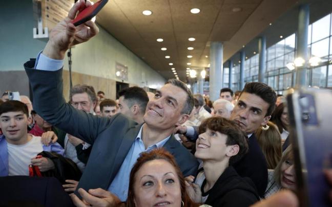 Pedro Sánchez se fotografía con dos simpatizantes mientras participa en su primer acto de la precampaña gallega.