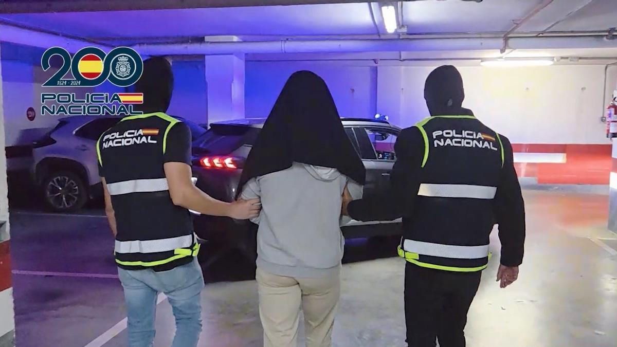 Dos agentes de la Policía Nacional con una persona detenida por su presunta vinculación al terrorismo yihadista.